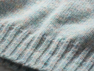Close-up of a soft, textured fabric with subtle pastel colors and ribbed knitting pattern.