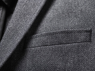 Close-up of a sleek black suit jacket fabric texture with a neatly stitched pocket.