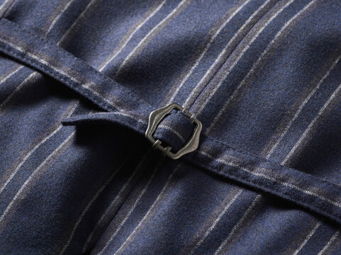 Close-up of a blue striped fabric with a metal buckle detail in focus.
