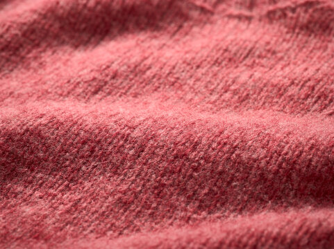 Close-up of textured pink fabric with visible weave pattern in soft focus.