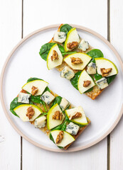 Bruschetta with spinach, honey, blue cheese, pear, and nuts. Healthy eating. Vegetarian food.