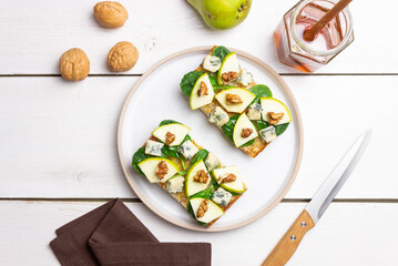 Bruschetta with spinach, honey, blue cheese, pear, and nuts. Healthy eating. Vegetarian food.