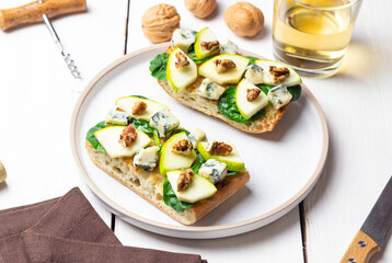 Bruschetta with spinach, honey, blue cheese, pear, and nuts. Healthy eating. Vegetarian food.