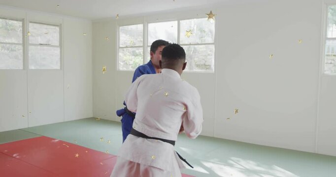 Uke stepping, gripping; tori pivoting for hipthrow on mats during dojo drills, gold stars overlay