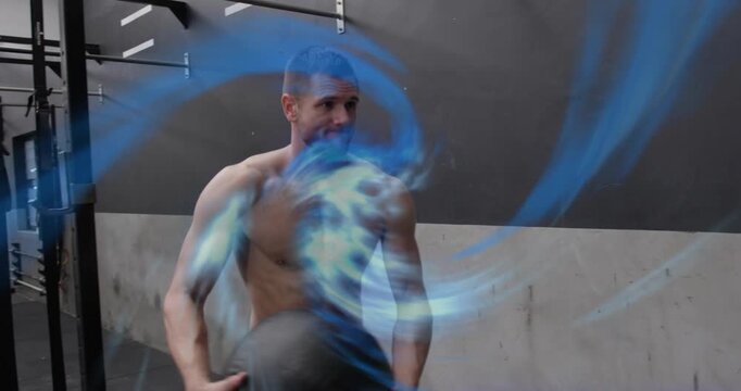 Man winding medicine ball and launching rotational throws blue swirl following motion, for fitness