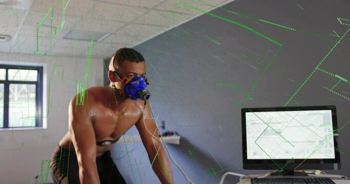 Male cyclist pedaling bike in fitness lab, PC capturing data, green graphs showing mask sensors