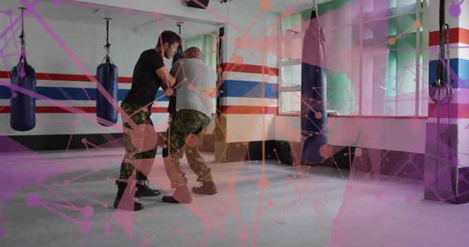 Martial arts pair starting clinch, pivoting and drilling takedown, pink overlay partly hiding frame