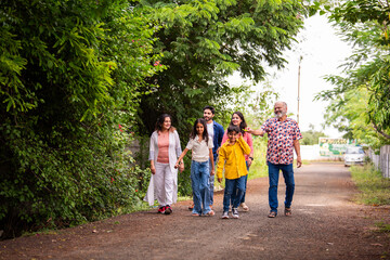 Indian family enjoying outdoor walk and laughter while bonding together on road