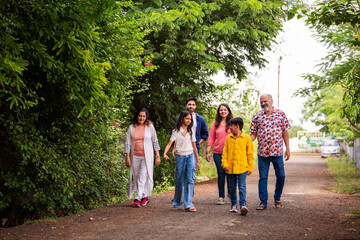 Indian family enjoying outdoor walk and laughter while bonding together on road
