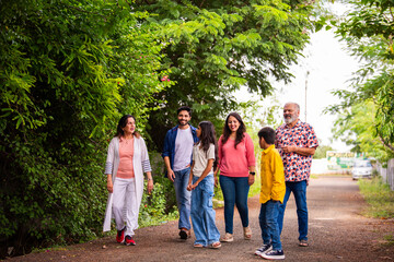 Indian family enjoying outdoor walk and laughter while bonding together on road