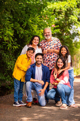 Obraz premium Indian family bonding happily while standing outdoors and smiling together