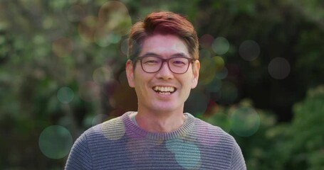 Cam rolling, presenter smiling into laughing as bokeh overlays growing over face for marketing