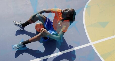 Tired sports player lowering hand, adjusting basketball to rest as blue overlay showing over player
