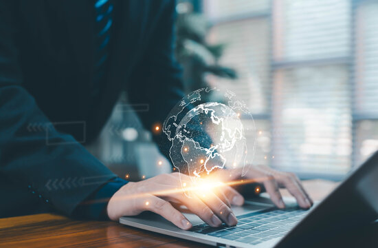 Business person typing on laptop with digital globe hologram, representing global connection, data networks, technology innovation, online communication for modern business and digital transformation