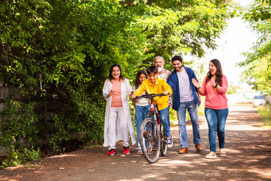 Indian kid learning bicycle with family support and joyful outdoor bonding