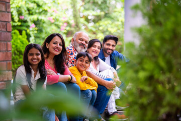 Indian family enjoying outdoor bonding time on steps during weekend relaxation