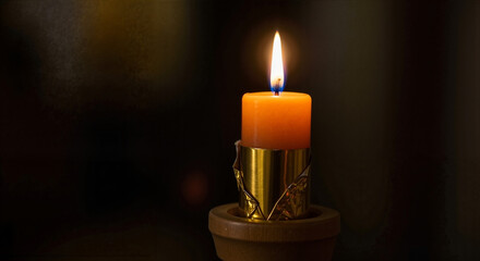 Single orange candle glowing in a decorative holder against a dark background