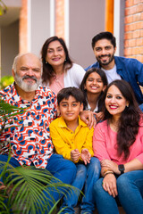 Indian family enjoying outdoor bonding time on steps during weekend relaxation