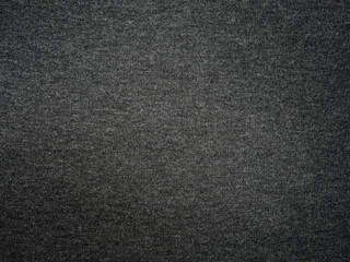 Black knitted fabrics with intricate textures background, uniform weave pattern, flat surface without folds, soft shadow gradient, luxury fashion texture.