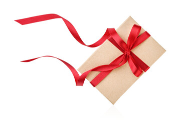 Christmas gift box wrapped in paper and decorated with red ribbon and bow isolated on white background with clipping path. Christmas, Valentines Day or Birthday celebration themes. Design element.