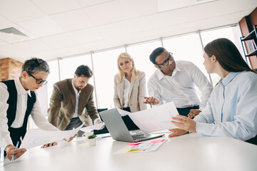 Obraz premium Professionally diverse team collaborating on project ideas in a modern office space with visuals and technology.