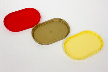 Some colorful plastic container lids on a white background, copy space, background and texture