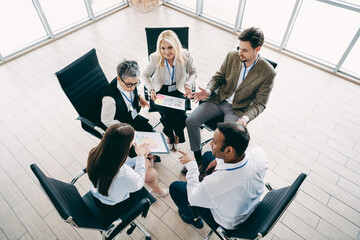 Diverse professionals discussing a business project during a collaborative meeting in a modern office setting
