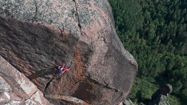 Climber abseiling down a huge cliff