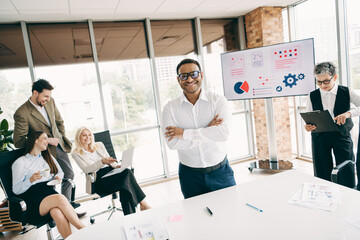 Confident leader and diverse business team collaborating in a modern office with digital presentation tools and technology