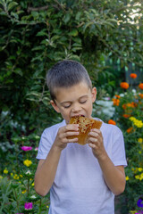 Boy eating fresh honey directly from the honeycomb in a summer garden