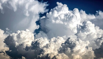 Large, fluffy cumulus clouds dominate the blue sky. Dramatic lighting