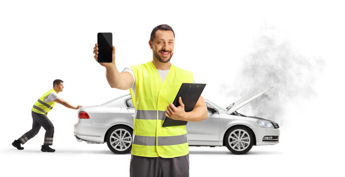Man in a reflective vest holding a smartphone and worker pushing a vehicle