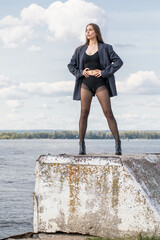 Full length portrait of a young brunette  in a formal jacket and black tights
