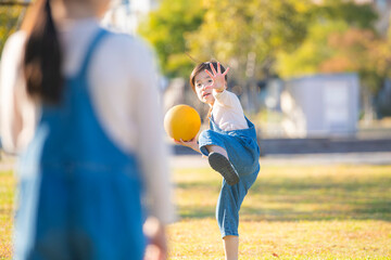 公園でボールを投げる元気な女の子