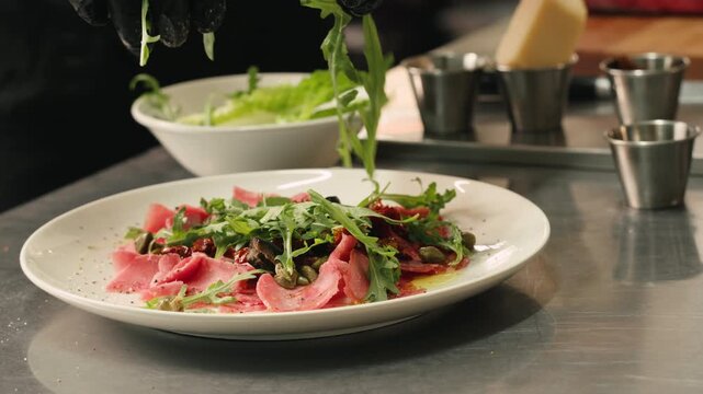 Delicious Spanish or italian ham served as rolls with green olives on white plate, chef cooking buffet menu. 