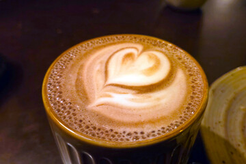 Heart Latte Art on Frothy Cup of Coffee in Cozy Cafe Setting