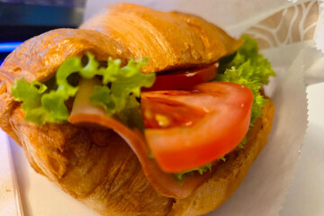 Delicious Fresh Croissant Sandwich with Ham, Lettuce, and Tomato for Breakfast or Lunch