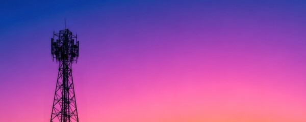 Silhouette of a telecommunication tower against a vibrant gradient sky at sunset. Wireless phone antenna serving modern mobile network.