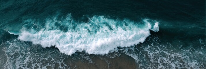 Aerial view of ocean waves crashing on sandy beach shoreline