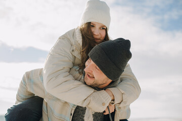 Father giving piggyback ride to smiling daughter
