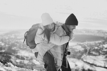 Father carrying smiling daughter on winter piggyback ride
