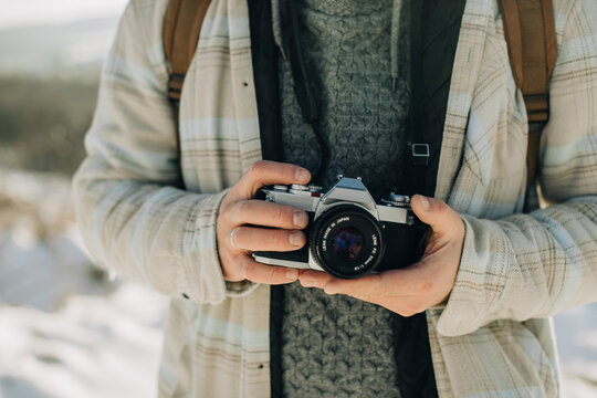 Person holding vintage film camera outdoors