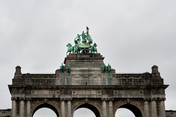 Detailed view of the bronze quadriga and statues crowning the Cinquantenaire Arch in Brussels. The monument honors Belgian independence and features neoclassical architectural details.