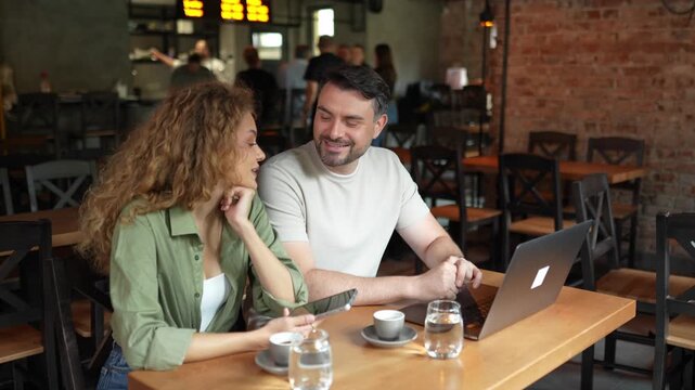 Romantic couple talking and working in a modern coffee shop