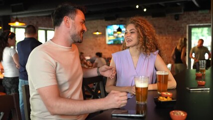 Young couple enjoying conversation over beers in a pub