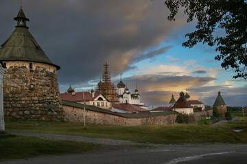 Historic stone fortress and monastery towers on Solovetsky Island at sunset, dramatic clouds and ancient architecture.