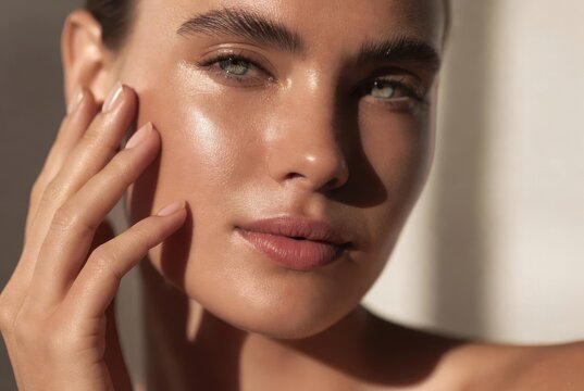 Close-up of a young woman with radiant, healthy skin, natural glow, and striking green eyes