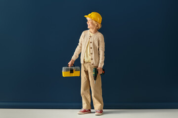 Blonde boy with wavy hair plays with tools in a cheerful studio setting