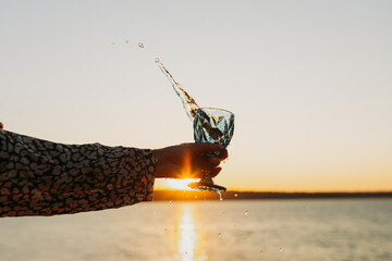Wine Glass in Hand Against Sunset Sky and Sea &ndash; Toasting to Beauty and Freedom