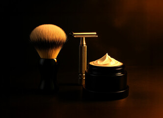 Luxury shaving set with brush, safety razor and cream on dark background. Elegant grooming tools illuminated with warm light. Premium barber and men’s skincare concept.